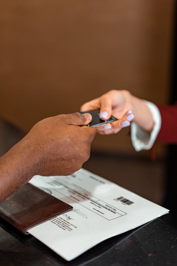 The Art of Drawing Readers In: Your attractive post title goes here Close-up of hands exchanging a credit card at a counter, highlighting a transaction in progress.